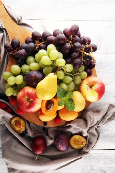 Frutas frescas de verano con manzana, uvas, bayas, pera y albaricoque
. - Foto, imagen
