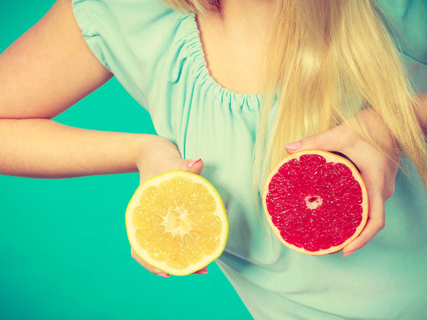 Dieta saludable, comida refrescante llena de vitaminas. Mujer sosteniendo deliciosos cítricos dulces, pomelo rojo y verde
. - Foto, imagen