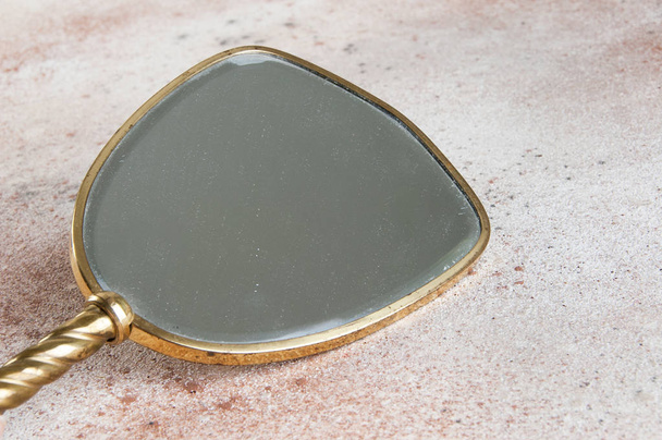 Vintage brass hand mirror on concrete background. Copy space for text. - Photo, Image