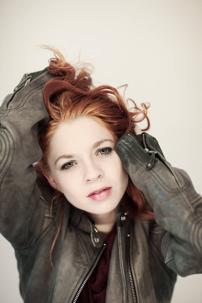 Portrait of a beautiful woman with perfect styled red curly hair and natural make up, cool, casual easy look in leather jacket, coat - Φωτογραφία, εικόνα