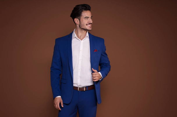 Elegant young man in an expensive fashionable suit posing in the studio, smiling. - Photo, image