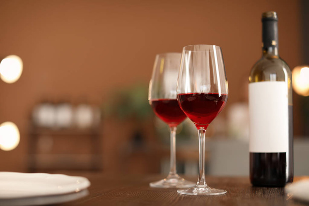 Glasses and bottle with tasty wine on table in restaurant - Foto, Imagen