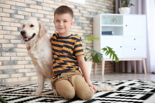 Lindo niño pequeño con su mascota en el suelo en casa
 - Foto, imagen
