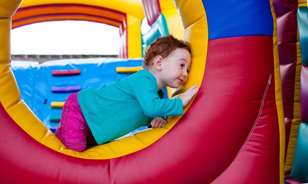 Adorável criança escondida em um castelo de trampolim
 - Foto, Imagem