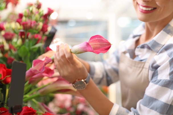 Female florist working in flower shop, closeup - Фото, изображение