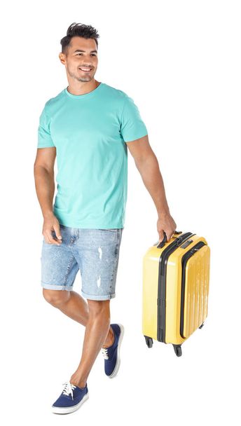 Young man walking with suitcase on white background - Foto, immagini