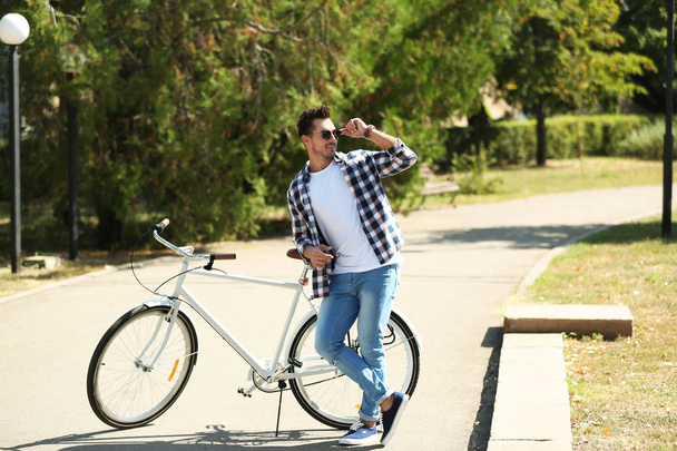 Komea nuori hipsteri mies polkupyörän puistossa
 - Valokuva, kuva