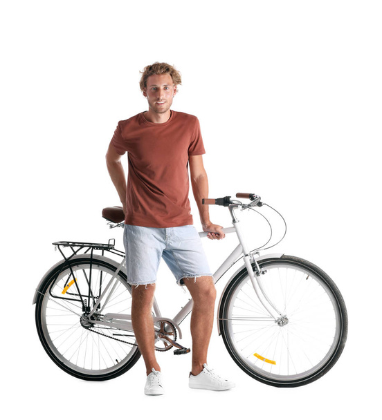 Handsome young man with bicycle on white background - 写真・画像