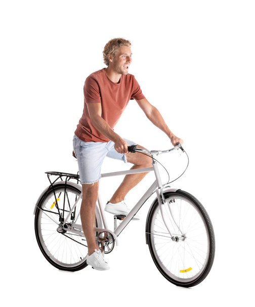 Handsome young man riding bicycle on white background - Фото, зображення