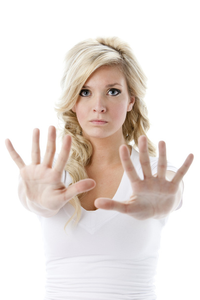Young woman holding her hands up as a warning or to say stop - Foto, afbeelding