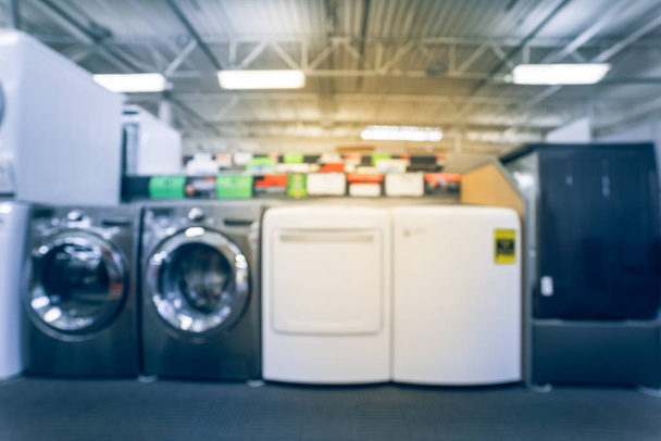 Blurred background retail store with rows of home appliances equipments. Defocused wide selection of washers and dryers set, stacked laundry center, laundry machines, tumble electric and gas dryer. - Photo, Image