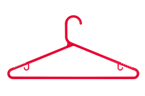 Красная пластиковая вешалка на белом фоне
 - Фото, изображение