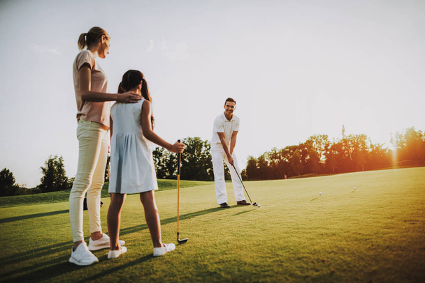 Happy Young Family Relax on Golf Field in Summer. Relaxing in Golf Club. Sports in Summer. Outdoor Fun in Summer. Family Fun Concept. Healthy Lifestyle Concept. Little Girl. Green Grass. - Foto, Bild