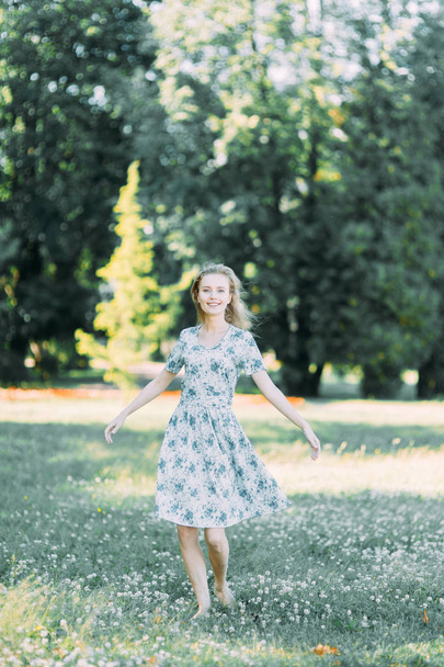 beautiful girl in the Park, in a summer dress and walking. Smiles and enjoys nature. St. Petersburg, Yelagin island - Фото, изображение