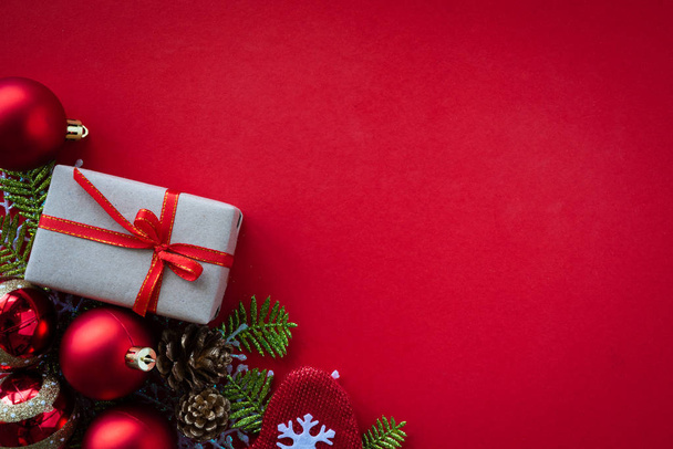 Kerstmis achtergrond concept. De doos van de gift van Kerstmis, dennenappels, fir takken, rode bal, gouden ster, rode sokken op rode achtergrond. - Foto, afbeelding