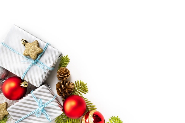 Noel concept de fond. Cadeau de Noël, cônes de pin, branches de sapin, boule rouge, étoile dorée, chaussettes rouges sur fond blanc
. - Photo, image