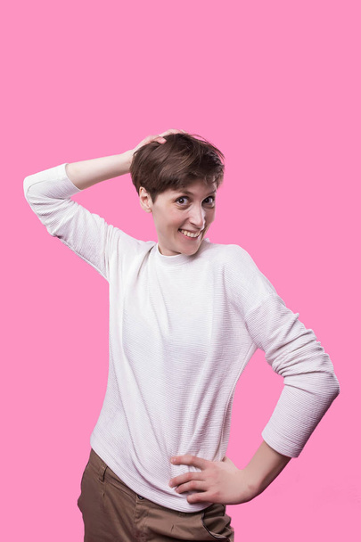 Front view of extremely happy and laughing young girl. Cute stylish model with shot haircut on trandy pink studio background. Female portrait. woman as teenager concept. Facial expression - Фото, зображення