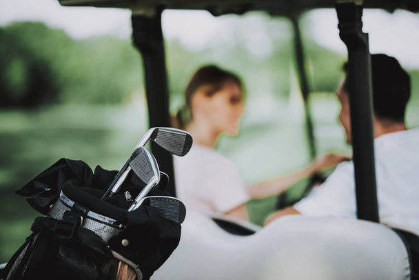 Happy Young Couple in White Cart on Golf Field. Young Family. Golf Club. Sports in Summer. Vehicle on Field. Outdoor Fun in Summer. Driver with Car. Healthy Lifestyle Concept. Couple on Vacation. - Foto, Bild