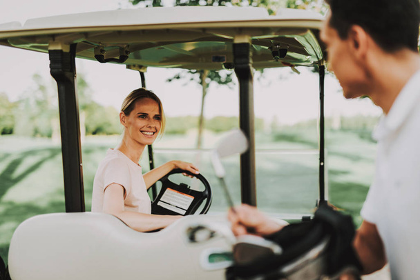 Happy Young Couple in White Cart on Golf Field. Young Family. Golf Club. Sports in Summer. Vehicle on Field. Outdoor Fun in Summer. Driver with Car. Healthy Lifestyle Concept. Couple on Vacation. - Fotó, kép