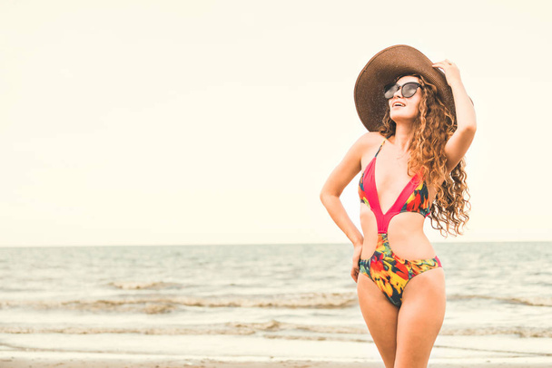 Jovem feliz vestindo maiô se divertindo na praia tropical no verão para férias de viagem de férias
. - Foto, Imagem