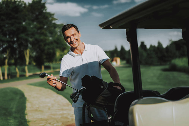 Young Man in White Shirt using Cart on Golf Field. Happy Young Man. Driver with Car. Healthy Lifestyle Concept. Golf Club. Sports in Summer. Vehicle on Field. Family Holiday. Outdoor Fun in Summer. - Zdjęcie, obraz