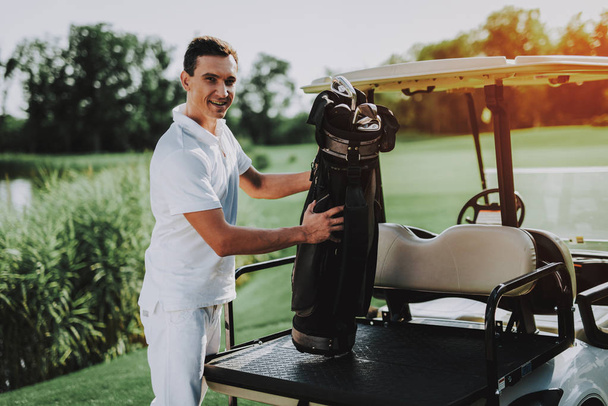 Young Man in White Shirt using Cart on Golf Field. Happy Young Man. Driver with Car. Healthy Lifestyle Concept. Golf Club. Sports in Summer. Vehicle on Field. Family Holiday. Outdoor Fun in Summer. - Foto, Imagen