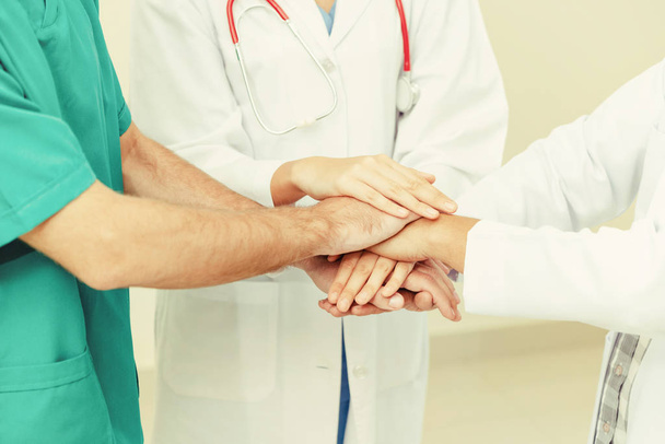 Trabajo en equipo del servicio médico: el médico, el cirujano y la enfermera unen sus manos
. - Foto, imagen