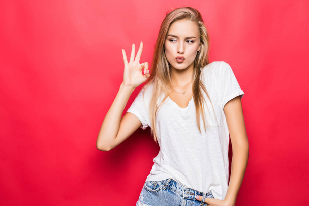 Close up portrait of girl gesturing ok sign isolated on red background - Photo, Image