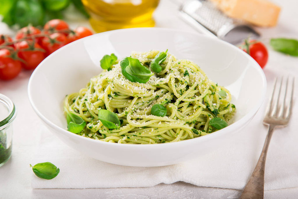 spaghetti pasta with basil pesto sauce and parmesan cheese on white bowl, selective focus - Foto, Imagem