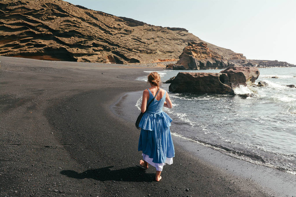 Dziewczyna spaceru na plaży na Morze Czarne, w Hiszpanii. Zdjęcie z dodano filtr film i ziarna. Widok z tyłu - Zdjęcie, obraz
