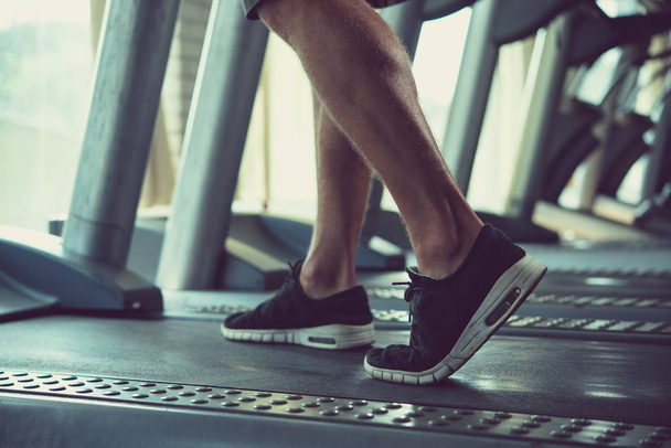 Sportler wärmt sich auf Laufband im Fitnessstudio auf - Foto, Bild