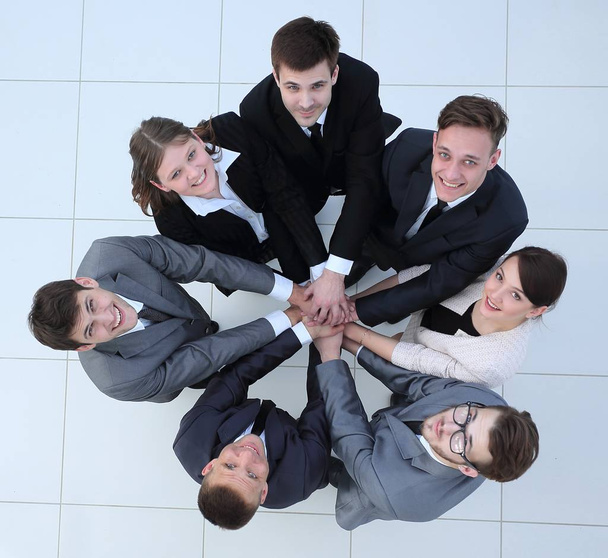 view from the top.business team holding hands and looking up. - Fotografie, Obrázek