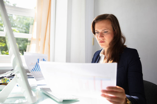 Concentrated Young Businesswoman Looking At Documents In Office - Foto, Imagem