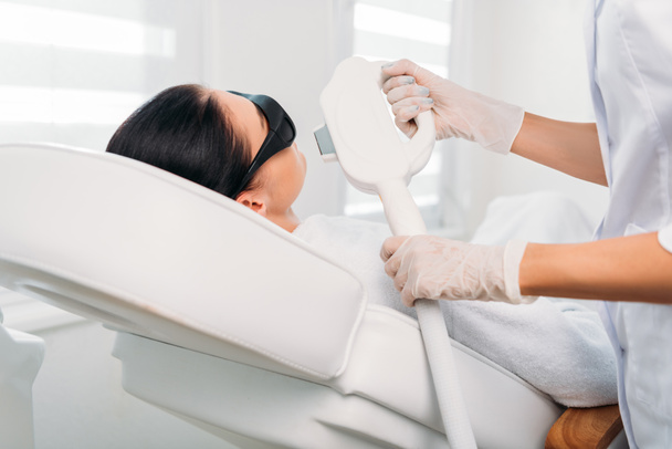 Žena v ochranné brýle se laserové epilace provádí kosmetička v salonu spa - Fotografie, Obrázek