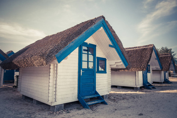 Kék-fehér festett kunyhók sora tengeri üdülőhelyen. - Fotó, kép