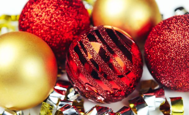 Λαμπερά Χριστούγεννα μπάλες κόκκινες και χρυσές με κομφετί από αλουμινόχαρτο. Κοντινό πλάνο. Η έννοια της εορταστική διάθεση. - Φωτογραφία, εικόνα