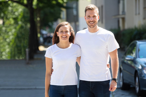 Porträt eines lächelnden jungen Paares auf der Straße - Foto, Bild