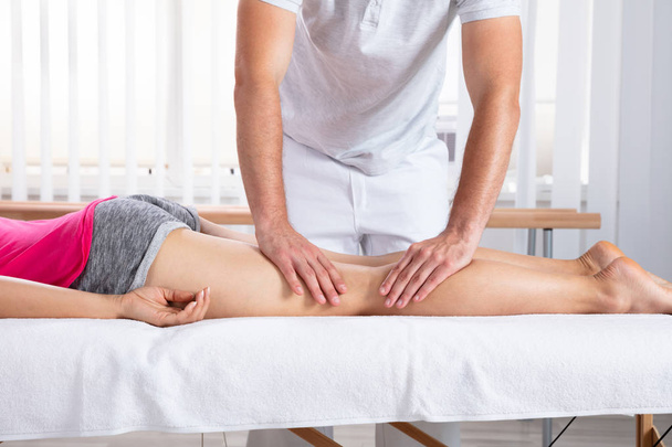Relaxed Young Female Patient Receiving Massage By Therapist In Clinic - Zdjęcie, obraz