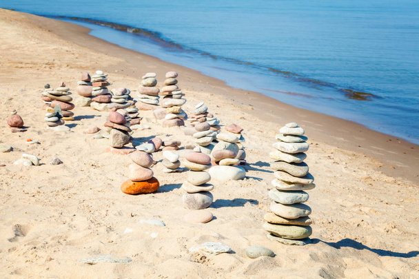 Piramidi di pietre equilibrate sulla spiaggia nella giornata estiva
 - Foto, immagini