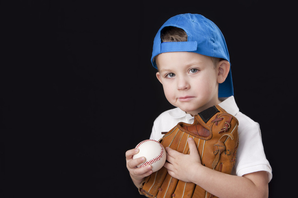 Portrait of little boy wearing baseball cap and holding baseball mitt - Foto, Imagen