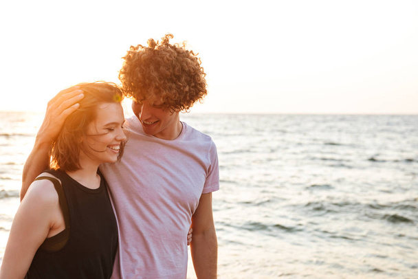 Image de mignon jeune couple amoureux marchant à l'extérieur sur la plage
. - Photo, image