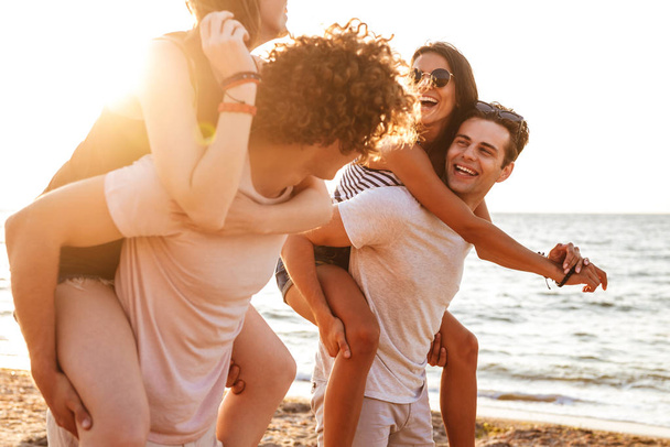 Image of excited group of friends loving couples walking outdoors on the beach having fun. - Valokuva, kuva