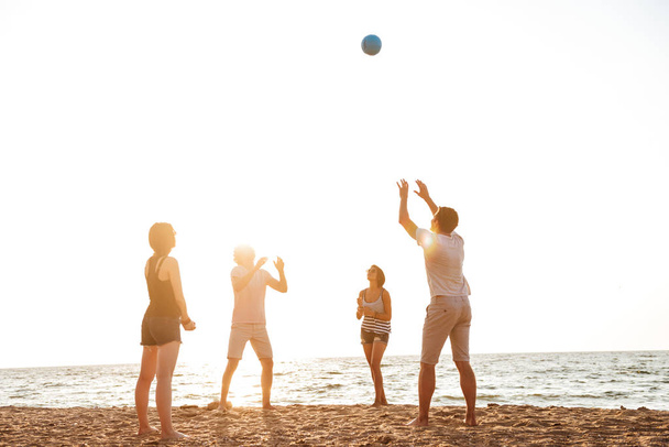 Foto di amici felici all'aperto sulla spiaggia giocare a pallavolo divertirsi
. - Foto, immagini