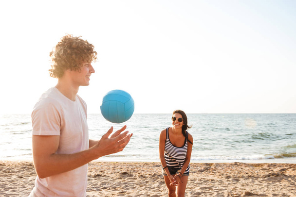 Photo of happy friends outdoors on the beach play volleyball having fun. - Foto, immagini