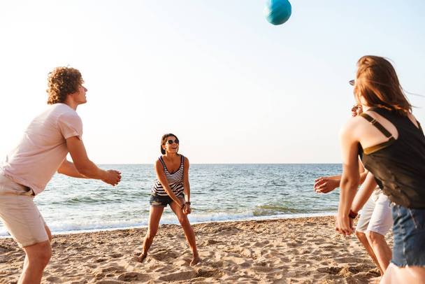Photo of happy friends outdoors on the beach play volleyball having fun. - Photo, Image
