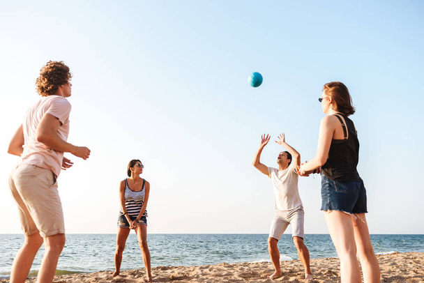 Photo of happy friends outdoors on the beach play volleyball having fun. - Foto, Imagem