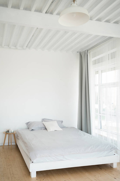 A wooden bed near the window. Interior details. Hugge. Furniture. - Фото, зображення