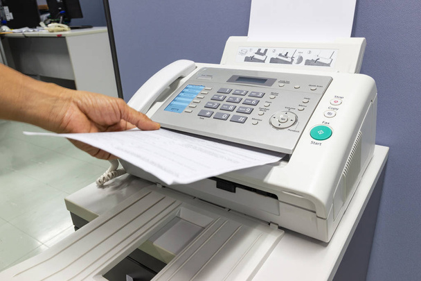 mano hombre está utilizando una máquina de fax en la oficina, concepto de negocio
  - Foto, Imagen