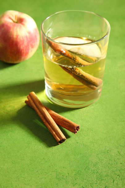 Cider, apples and cinnamon on green background. Concept alcohol. - Photo, Image