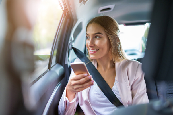 Woman with smart phone in a car - Zdjęcie, obraz